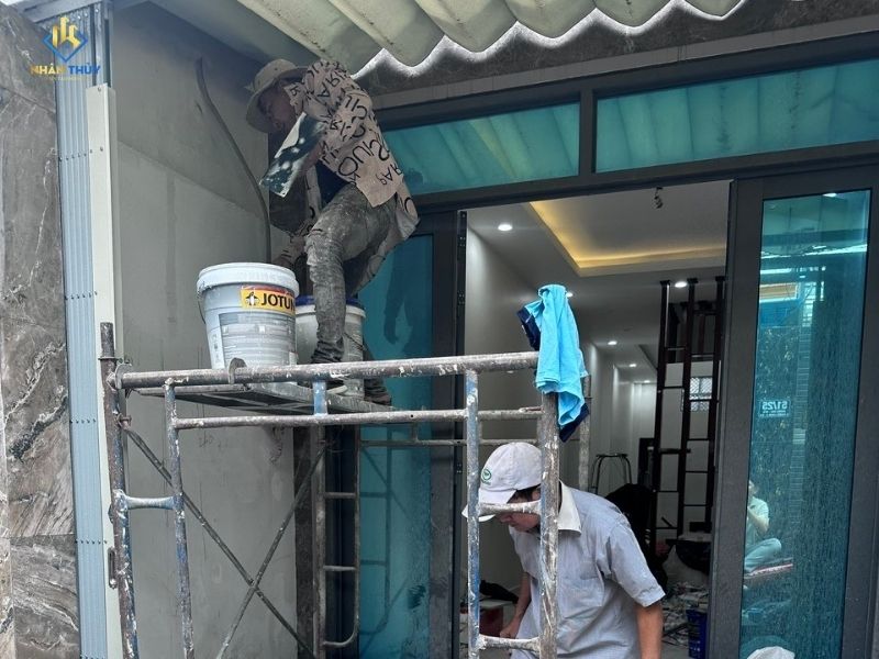 thợ đang sơn khu vực sân để xe