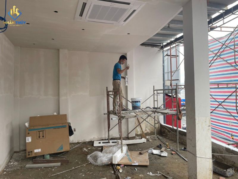 Thợ sơn hoàn thiện tường nội thất trên giàn giáo di động