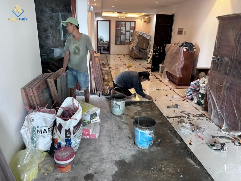 thợ đang tiến hành sơn nước kết hợp lát gạch nền nhà