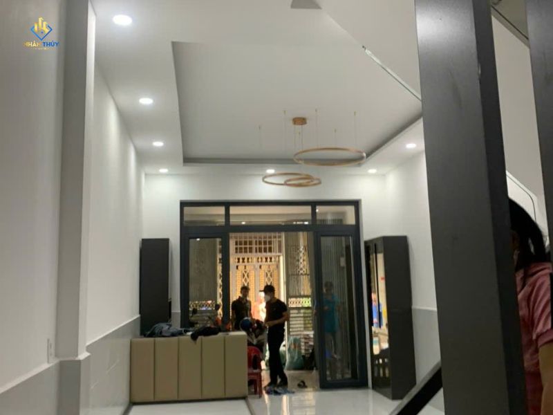 Không gian nội thất tường và trần màu sáng, cửa kính khung đen và đèn tròn