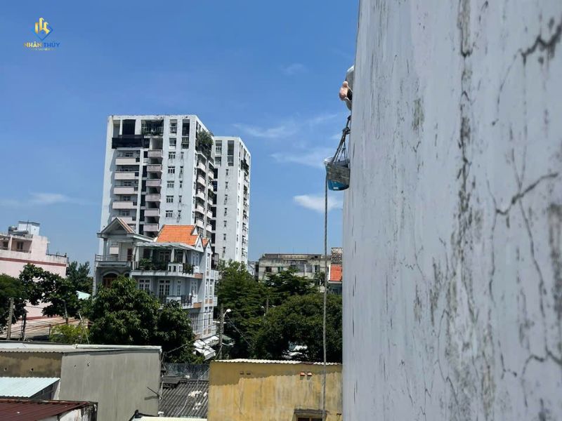Thợ thi công trên bề mặt tường ngoài có vệt loang tại công trình bình dương