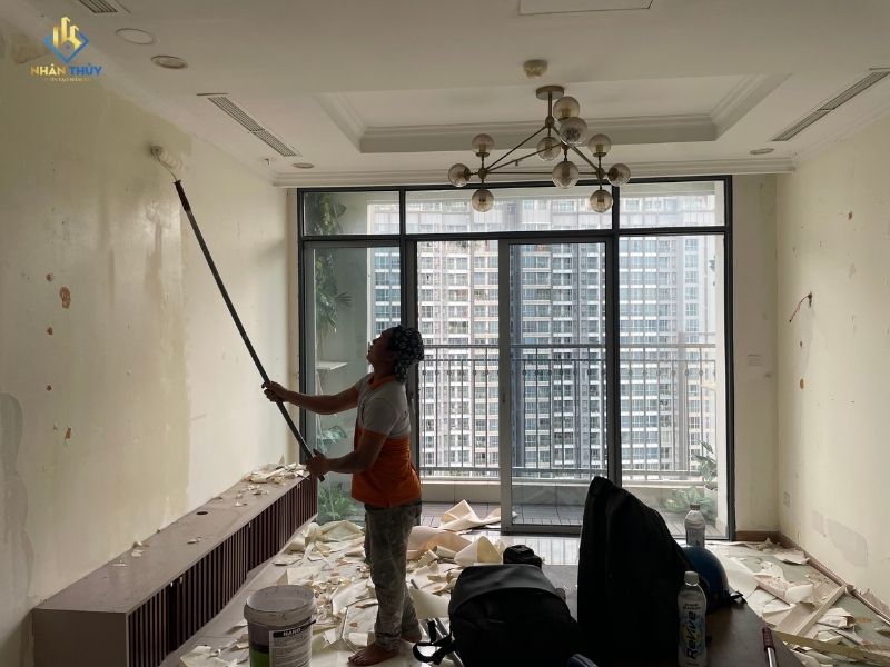 Thợ xử lý tường phòng khách sau khi bóc giấy dán tường