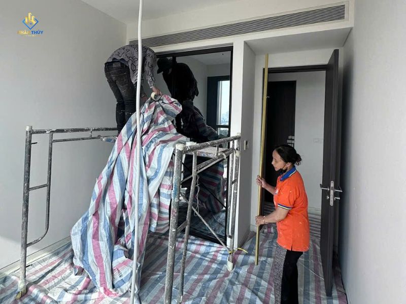 Đội thợ che chắn sàn và khu vực nội thất trước khi sơn