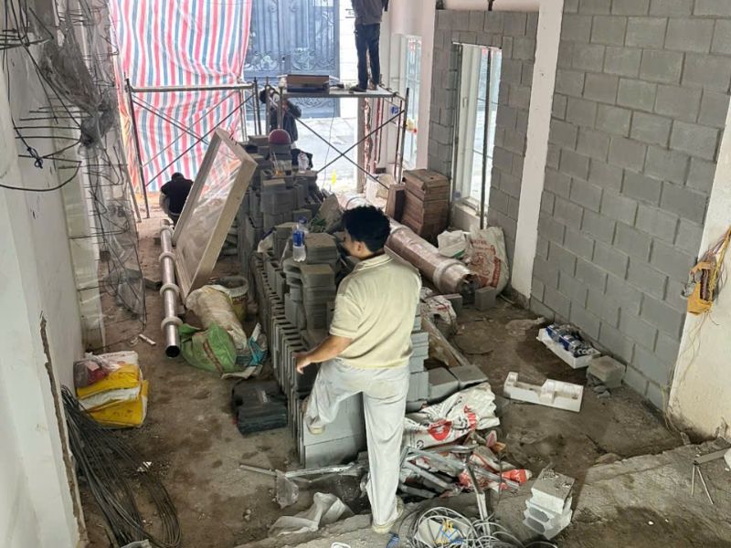 Mặt bằng sửa nhà chật hẹp với vật tư và xà bần tập kết trong khu vực thi công