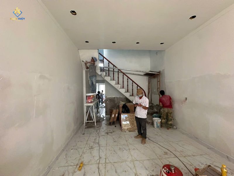 Thợ làm việc trên mảng tường nội thất cạnh cầu thang tại công trình sơn bả TP.HCM