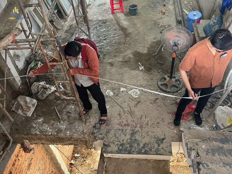 Kỹ thuật Nhân Thủy đo khối lượng và ghi chú hiện trạng tường tại buổi khảo sát
