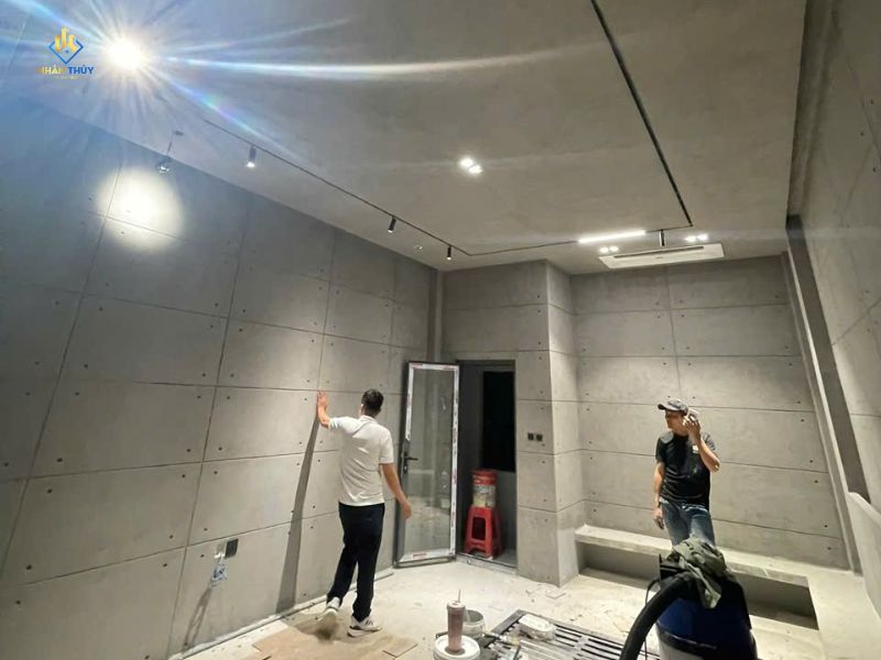 Người kiểm tra bề mặt vách còn thấy mối nối và đầu vít trong phòng đang thi công