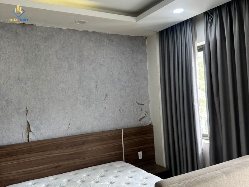 Tường đầu giường phòng ngủ bị bong nứt trước khi sửa chữa