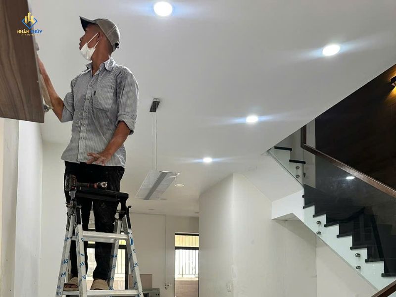 Thợ Nhân Thủy kiểm tra bề mặt tường tại nhà chị Trinh ở Bình Trưng