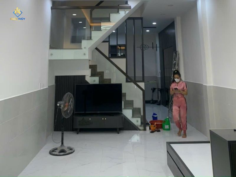 Phòng khách nhà chị Oanh tại Tân Phú sau cải tạo với nền gạch sáng và cầu thang