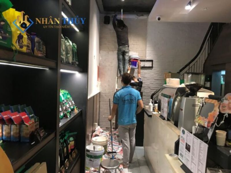 Thi công sơn cửa hàng cafe vào buổi tối, có che chắn khu vực làm việc