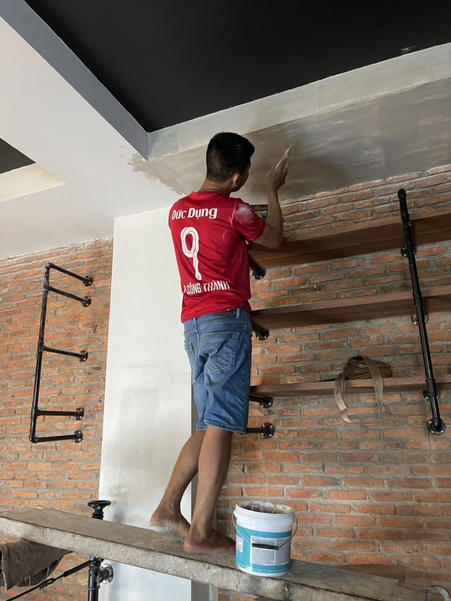 Thợ xử lý bề mặt trần phía trên hệ kệ Frankies