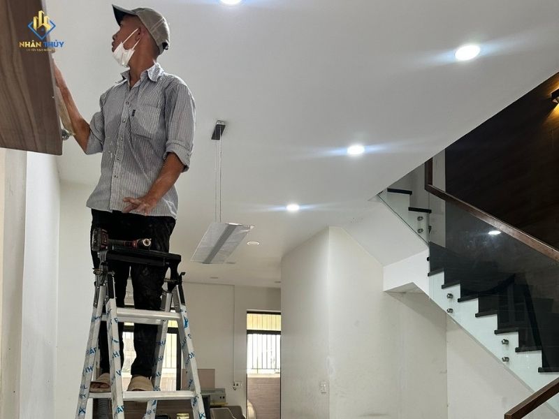 Thợ Nhân Thủy xử lý bề mặt tường tầng 1 bằng thang nhôm