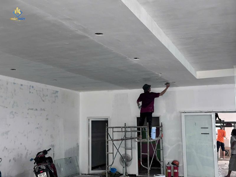 Thợ sơn thi công trần và tường nội thất trên giàn giáo
