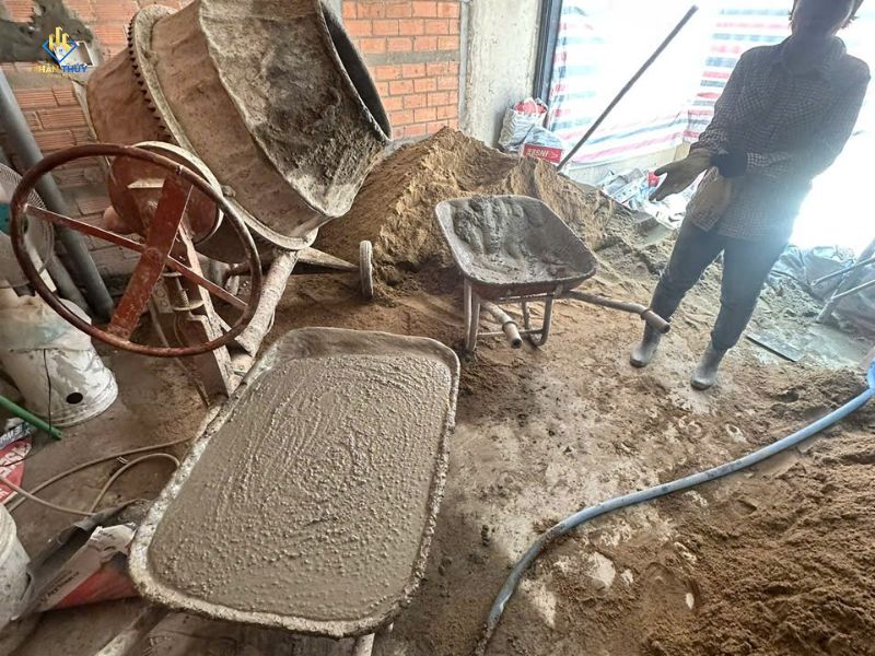 Thợ trộn vữa bằng máy trộn và xe rùa phục vụ xây tô tại công trình nhà phố quận 2