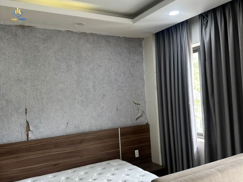 Tường đầu giường phòng ngủ nhà chị Trinh bị bong nứt trước khi sửa